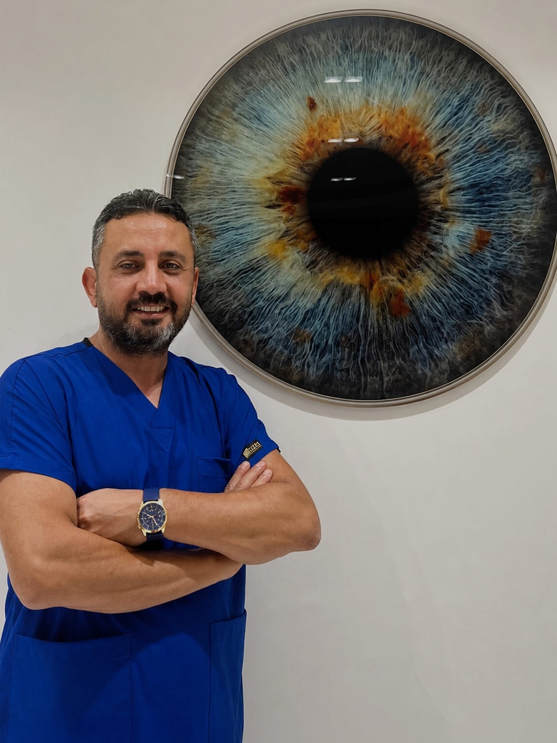 Op. Dr. Birol Coşkun, kliniğindeki iris tablosunun önünde
